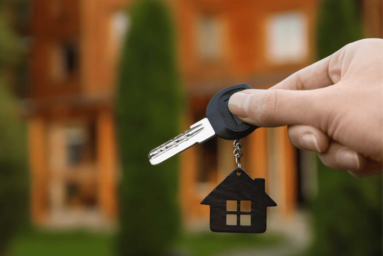 Hand holding a house-shaped keychain