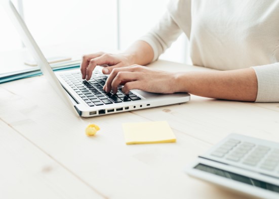 Woman using a laptop and calculator