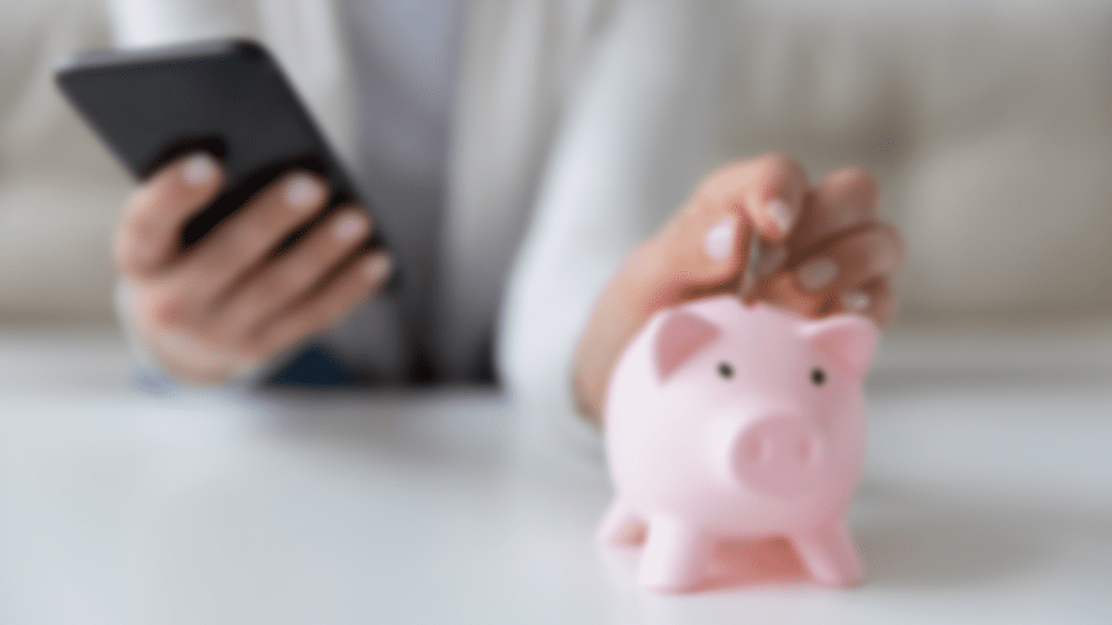 woman putting money in piggy bank