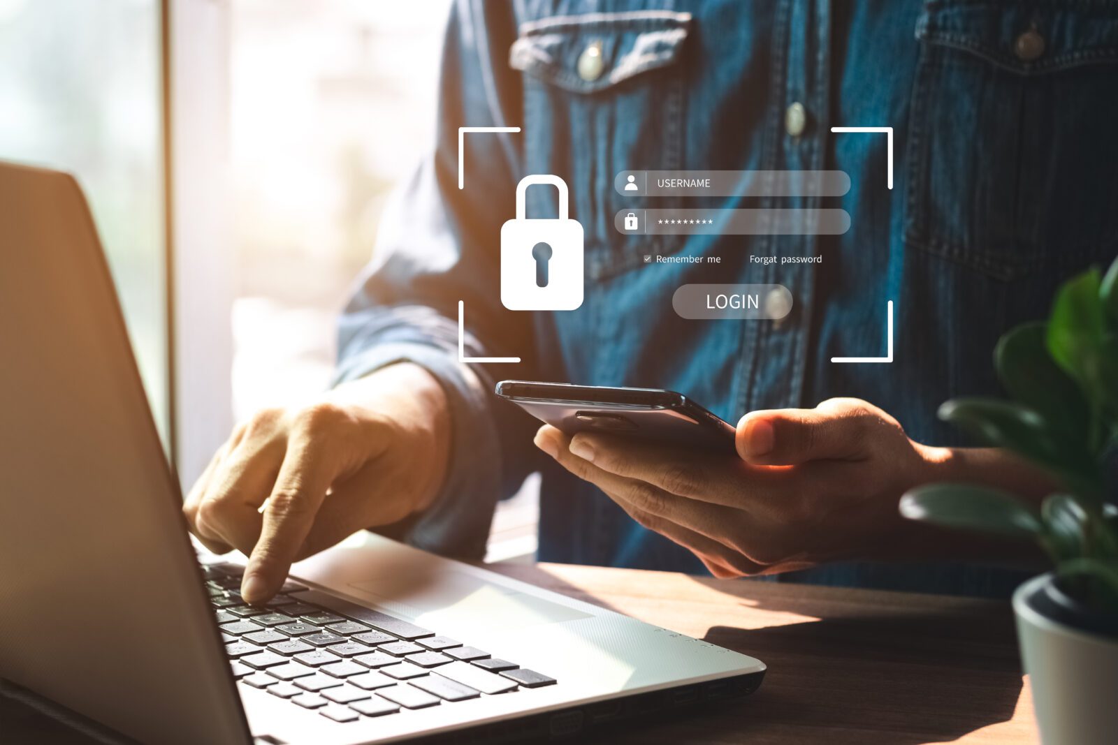 Cybersecurity - Man on a computer with Password and Login screen and mobile phone for MFA