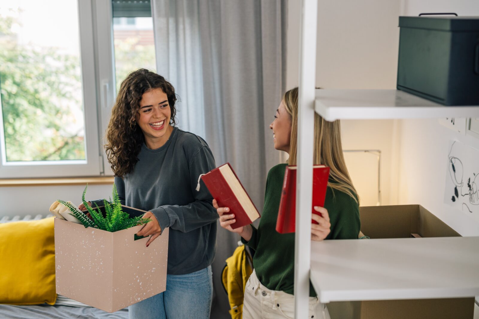 Two college students moving into their dorm room.