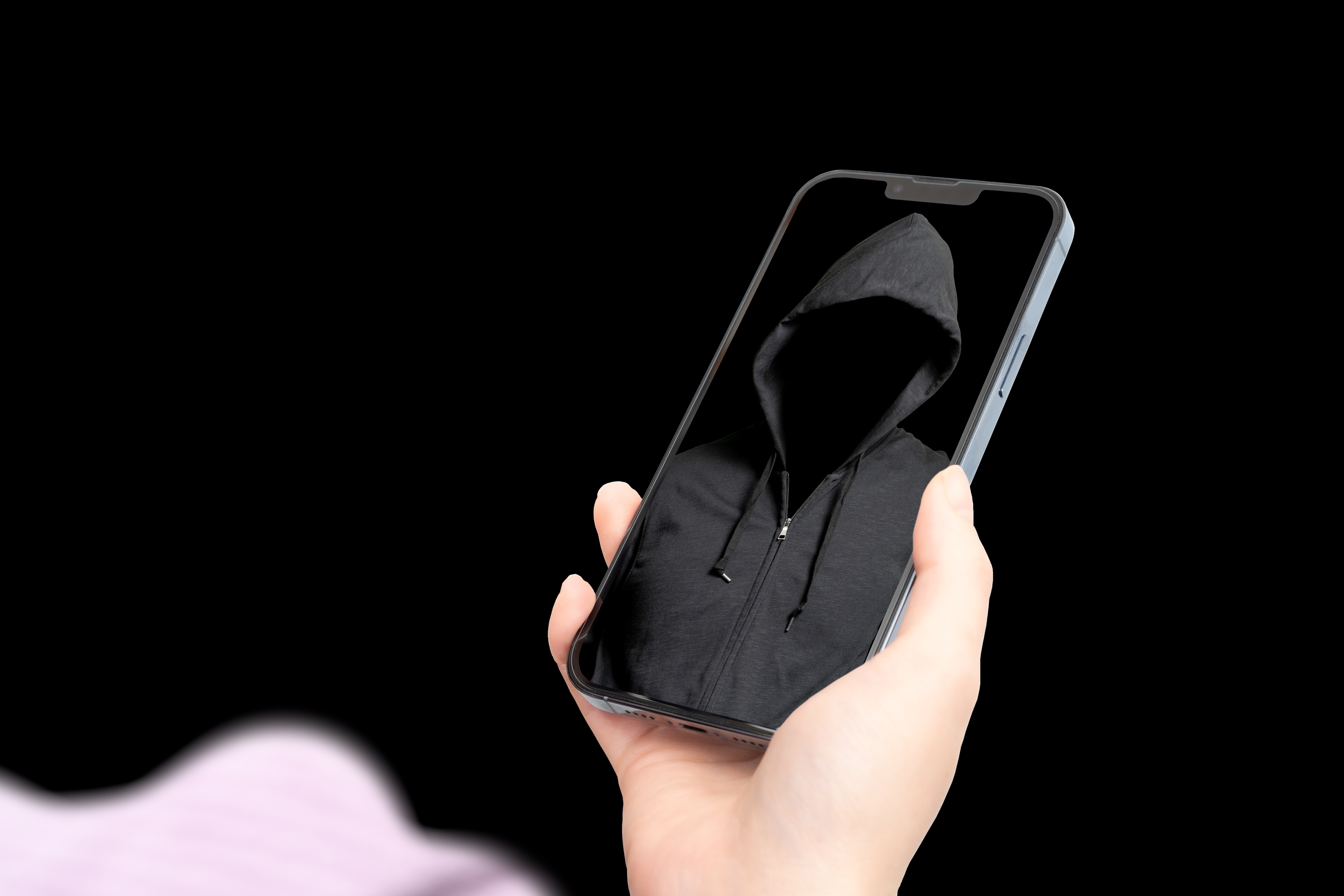 Cell phone with a scary, hooded figure reflected in the screen