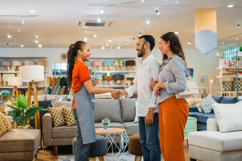 A young couple shop for furniture in a large store.
