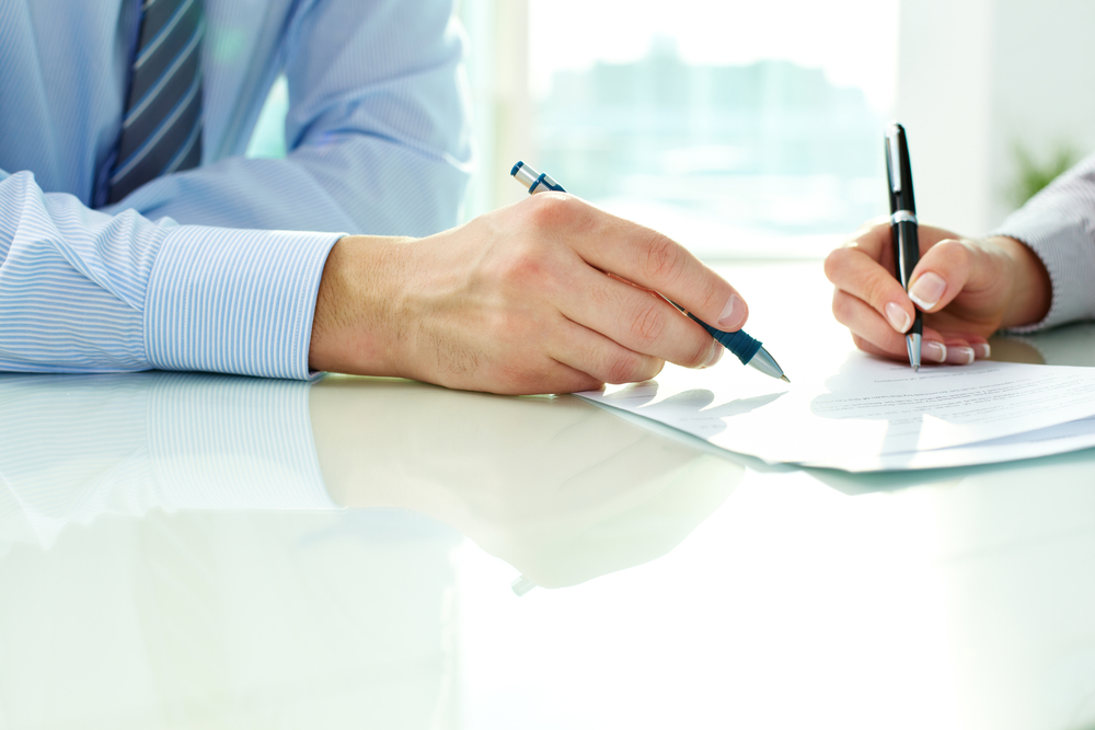 Business people signing paperwork for letters or line of credit